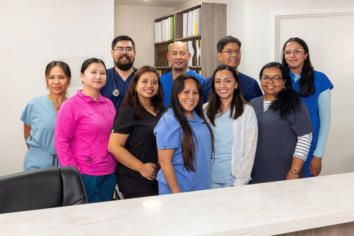 Group of Arden Park staff members posing together behind a counter.